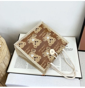 Detail of cute bear jute tote bag with wooden button closure and woven handle texture