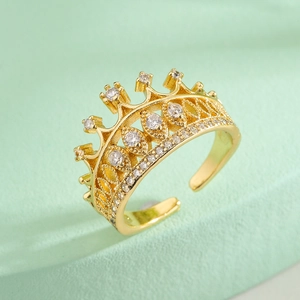 Elegant 18K gold plated crown ring with zircon crystals on a green background