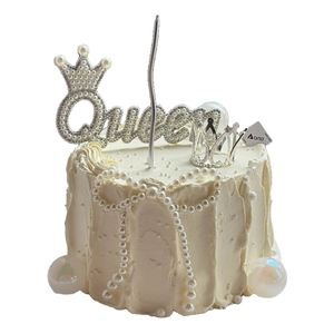 Silver Queen crown cake topper with pearls and rhinestones on white cream cake