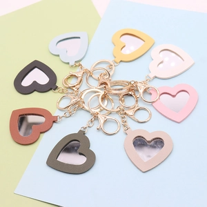 Macro shot of colorful PU leather heart-shaped mirror keychains in Morandi tones