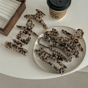 Set of 8 tortoise shell acetate hair claws in various geometric shapes on a desk