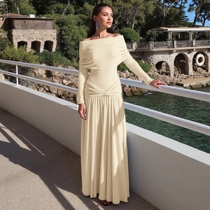 Detail of elegant cream off-the-shoulder maxi dress featuring waist pleats and long sleeves