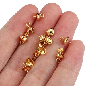 Macro shot of small gold stainless steel pearl cup bail on finger showing precise scale
