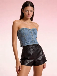 Détail d'un haut corset en jean bleu ajusté avec un short en cuir noir élégant