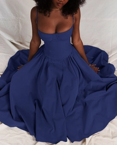 Detail view of structured corset bodice and pleated skirt of a navy blue vintage dress