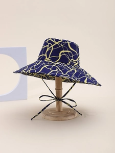 Detail of blue and yellow marble pattern sun hat with chin strap on a wooden stand