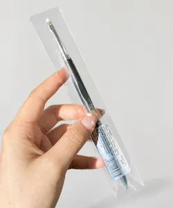 Detail of a small concealer brush with synthetic bristles and a gray slim handle