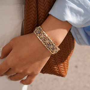 Close-up of vintage hollow floral gold bracelet with amber zircon on female wrist