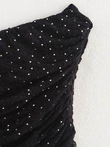 Détail du tissu en dentelle noire avec strass argentés et textures plissées élégantes