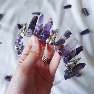 Macro detail of gothic amethyst crown featuring silver skull charms and raw crystal points