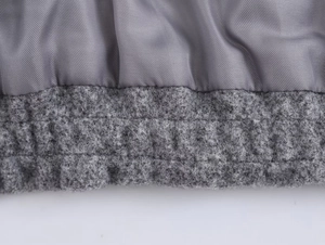 Close-up of gray wool fabric texture and smooth woven lining on a bomber jacket