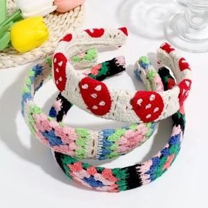 Detailed view of three handcrafted knit headbands with floral and strawberry embroidery