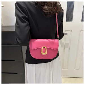 Pink PU leather saddle bag with gold metal buckle shown on a model in a casual outfit