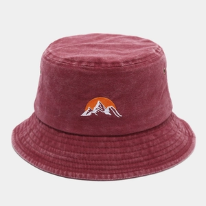 Detail of embroidered sun and mountain logo on washed dark red cotton bucket hat