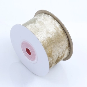 Close-up of champagne gold velvet ribbon roll with shimmering texture for DIY crafts