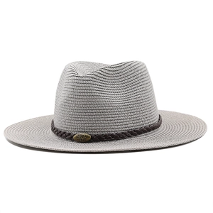 Detail of grey straw hat featuring a dark brown woven leather band and metal logo buckle