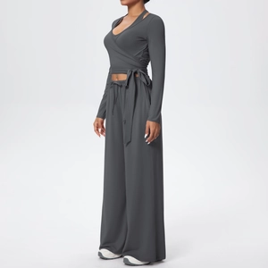 Détail d'un ensemble de yoga gris foncé avec haut cache-cœur à manches longues et pantalon