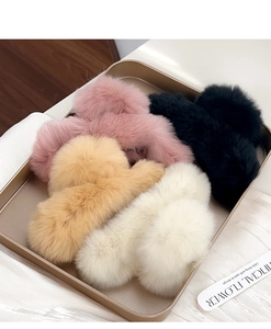 Plush faux rabbit fur hair claws in pink, black, khaki, and beige on a gold tray