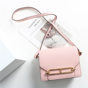 Vista ravvicinata di una borsa in pelle rosa martellata con fibbia in metallo e tracolla
