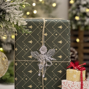 Clear acrylic angel Christmas ornaments hanging on a green gift box with warm bokeh background