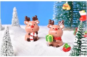 Detailed view of two miniature Christmas reindeer figurines with gift box and candy cane