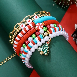 Gros plan d'un bracelet de Noël festif avec perles rouges et vertes et pendentif sapin
