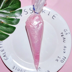 Close-up of deep pink pearlescent cream glue in a piping bag for DIY craft decoration