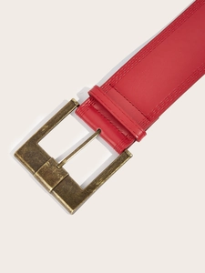 Close-up of red leather wide belt with antique bronze buckle and double stitching