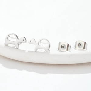 Macro shot of silver polished turtle-shaped stud earrings and butterfly backings
