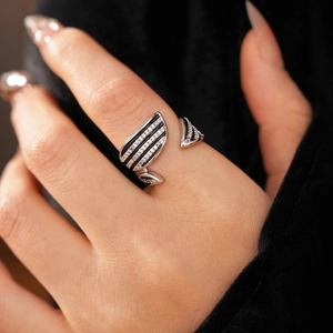 Macro shot of silver wing ring featuring micro-paved zircons and adjustable open band