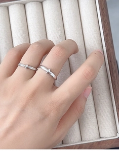 Close-up of couple rings featuring star-shaped motifs with zircon inlay on velvet box