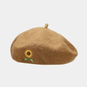 Close-up of vintage brown wool beret featuring detailed yellow sunflower embroidery detail