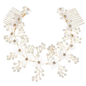 Detailed view of bridal hair combs featuring white flowers, pearls, and gold metal leaves