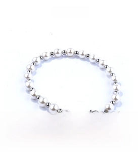 Detailed view of round white pearls and polished silver beads with lobster clasp