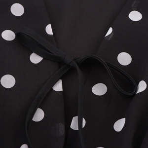 Robe à pois élégante sans manches avec décolleté en V profond et détail de nœud
