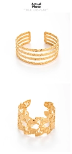 Detail of adjustable golden stainless steel bracelets with butterfly and textured designs