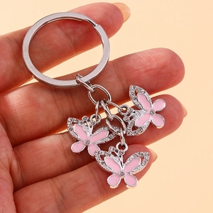 Detail of pink enamel butterfly keychain with sparkling crystals held in hand