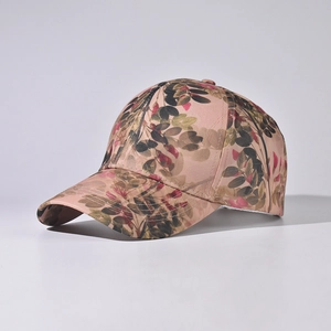 Detail of floral pattern stitching on pink-brown graffiti baseball cap outdoors