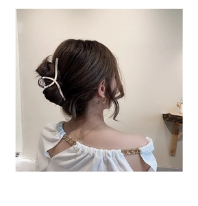 Close-up of elegant silver floral metal hair claw clip styled in a woman's bun hairstyle