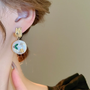 Detail of a French vintage floral resin earring with pearls and colorful gemstones
