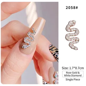 Macro detail of rose gold snake nail art charm encrusted with white rhinestones