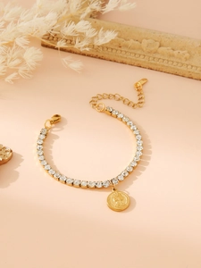 Gold tennis bracelet with white rhinestones and a detailed coin pendant relief