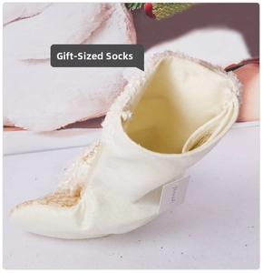 Detail of a beige Christmas stocking showing spacious interior and golden sequin pattern