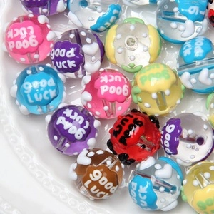 Macro detail of 6mm faux pearl beads with GOOD LUCK print for DIY jewelry making