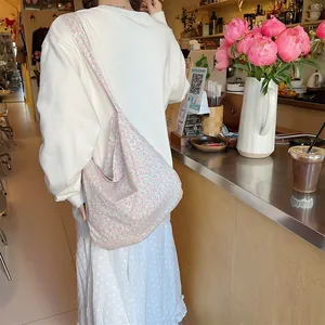 Detailed shot of large capacity floral canvas tote bag shown on a female model