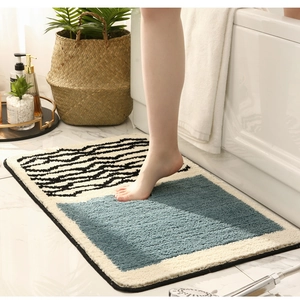 Absorbent plush bathroom mat with blue geometric pattern and anti-slip backing in use