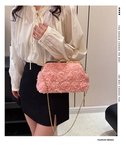 Close-up of pink 3D fabric rose flowers and crystal-encrusted gold clasp on evening bag