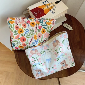 Close-up of floral and bear print cotton makeup bags with simple wish woven labels