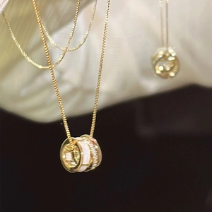 Elegant gold cylinder necklace with white shell inlay and sparkling cubic zirconia stones
