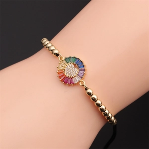Detail of gold beaded bracelet with rainbow gemstone ring and micro-paved heart pendant